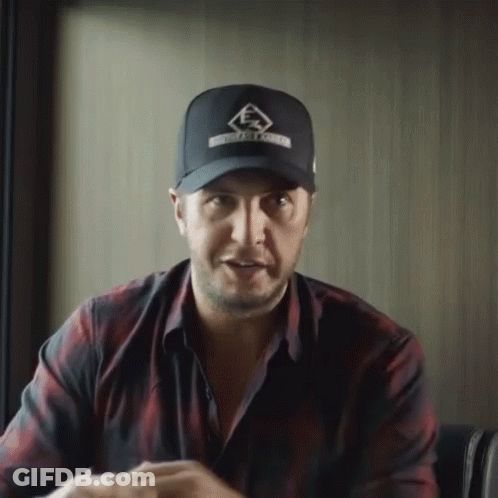 Man In Hat And Plaid Shirt Sitting GIF
