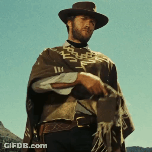 Man In Hat And Poncho Holding Gun GIF