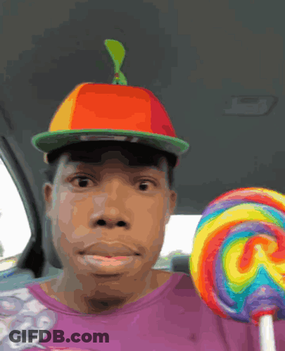 Man In Hat And Purple Shirt Holding Lollipop GIF