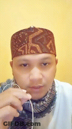 Man In Hat And Scarf Holding Earbuds GIF