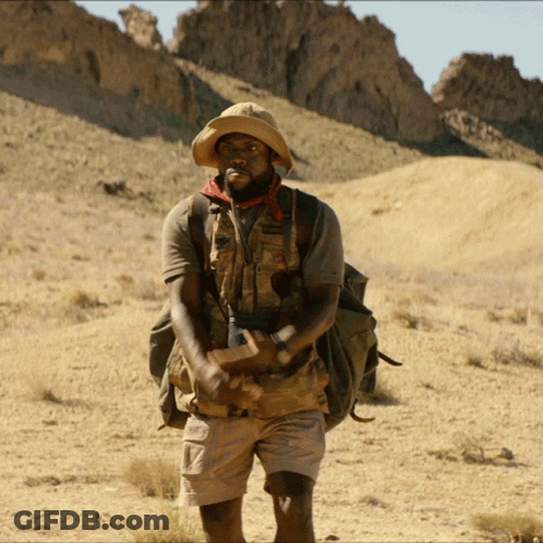 Man In Hat And Shorts With Backpack In Desert GIF
