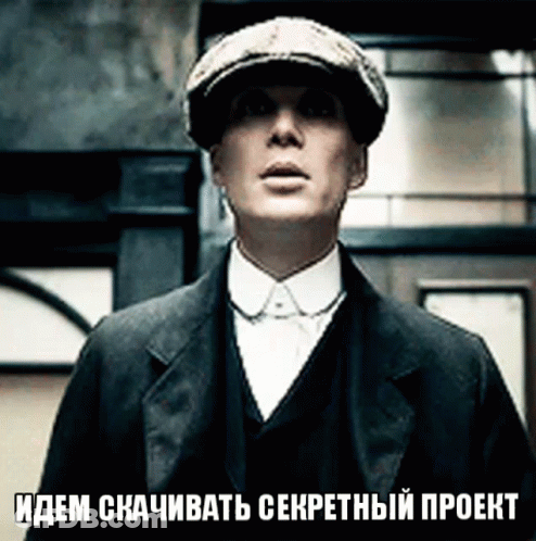 Man In Hat And Suit In Front Of Sign Идем Скачивать Секретный Проект GIF