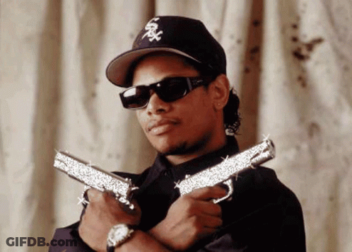 Man In Hat And Sunglasses Holding Two Guns GIF
