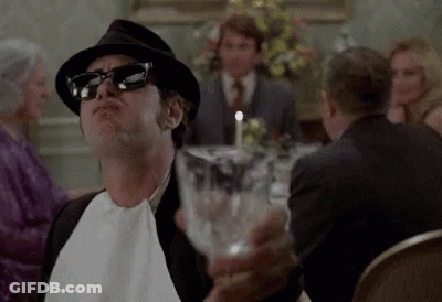 Man In Hat And Sunglasses Holding Water At Dinner Table GIF