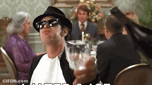 Man In Hat And Sunglasses Holding Wine At Table GIF