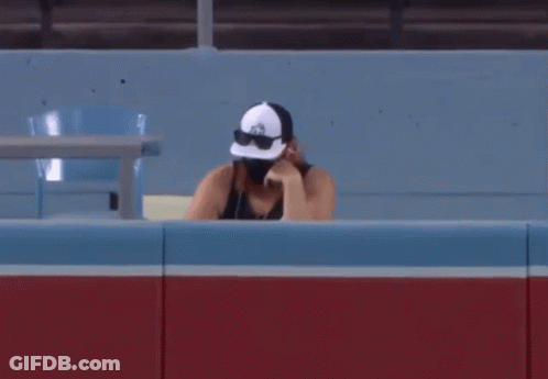 Man In Hat And Sunglasses Sitting In Stadium GIF
