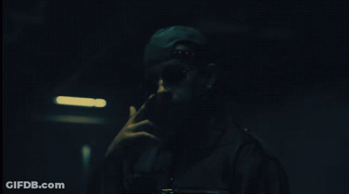 Man In Hat And Sunglasses Smoking Cigarette In Dark Room GIF