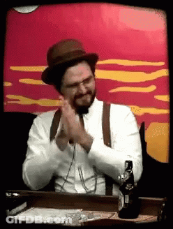 Man In Hat And Suspenders Sitting With Beer GIF