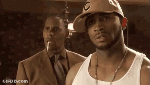 Man In Hat And Tank Top Next To Man In Suit And Tie GIF