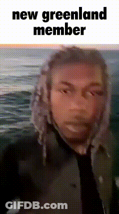 Man In Hat And Tie Standing Before Ocean Saying New Greenland Member GIF