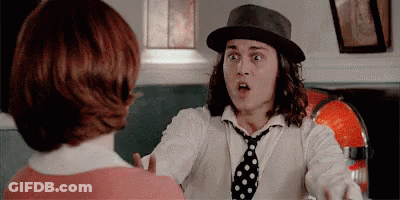 Man In Hat And Tie Talking To Woman In Red Shirt GIF