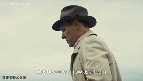 Man In Hat And Trench Coat Says Maybe We Can Row As A Team GIF