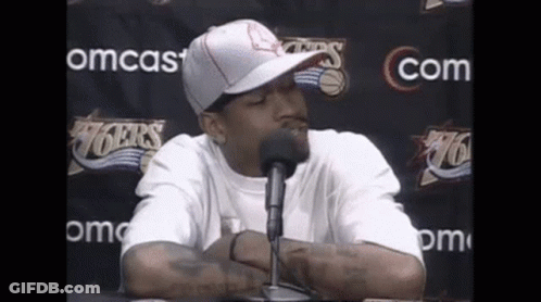 Man In Hat And White Shirt Talking Into Microphone GIF