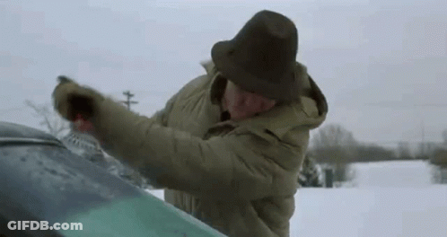 Man In Hat Cleaning Windshield In Snow GIF