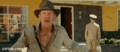 Man In Hat In Front Of Yellow House Number 138 GIF