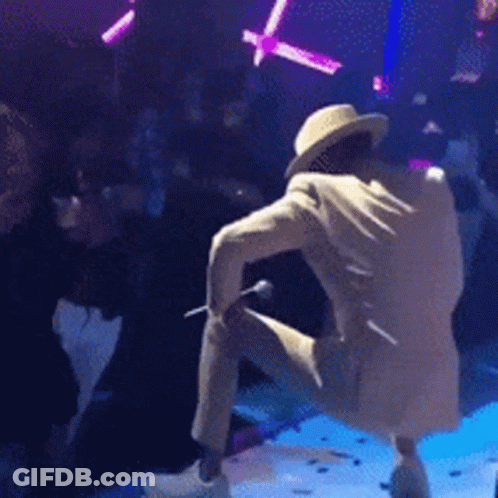 Man In Hat Kneeling On Stage With Microphone GIF