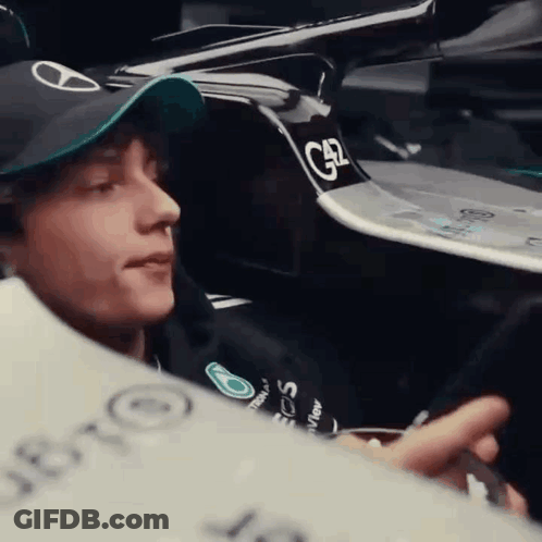Man In Hat Looking At Phone In Car GIF
