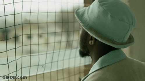 Man In Hat Looking Out Window GIF