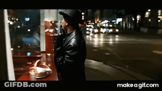Man In Hat Looking Out Window At City Night GIF