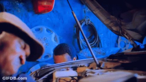 Man In Hat Looking Under Hood In Garage GIF