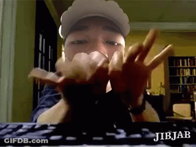 Man In Hat Making Peace Sign At Keyboard GIF