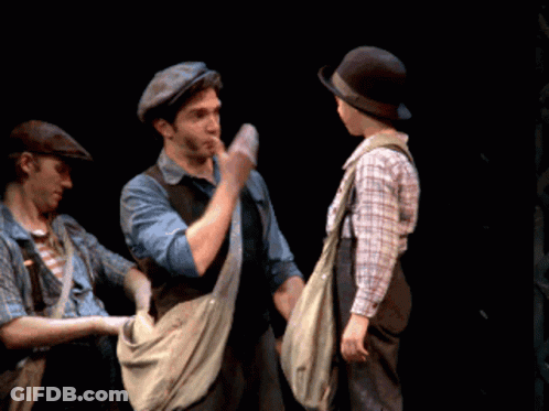 Man In Hat Shaking Hands With Boy In Overalls GIF