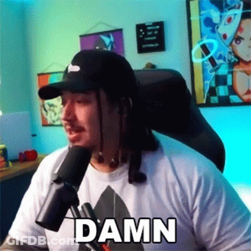 Man In Hat Sitting At Microphone With Damn Shirt GIF