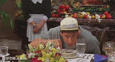 Man In Hat Sitting At Table With Plates And Glasses GIF