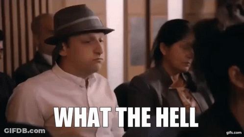 Man In Hat Sitting In Crowd Says What The Hell GIF