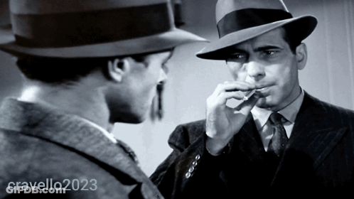 Man In Hat Smoking Cigarette Next To Man In Suit And Tie 2023 GIF