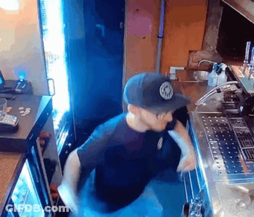 Man In Hat Standing At Restaurant Counter GIF