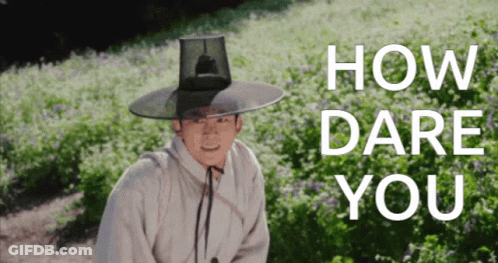 Man In Hat Standing In Flower Field Saying How Dare You GIF