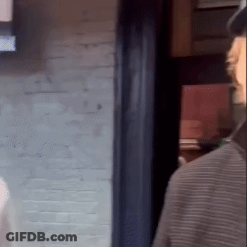 Man In Hat Standing In Front Of Brick Wall GIF