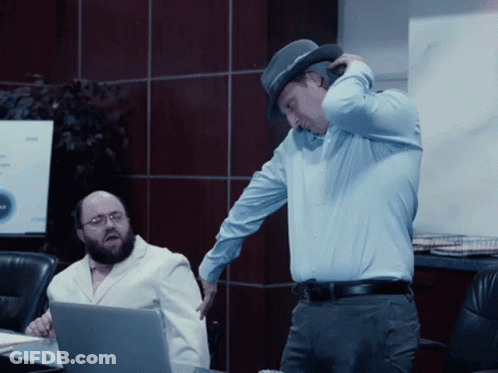Man In Hat Standing Next To Man In White Coat GIF
