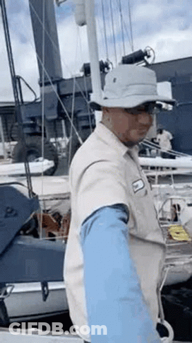 Man In Hat Standing On Boat GIF