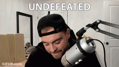 Man In Hat Stands At Microphone Saying Undefeated GIF