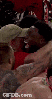 Man In Hat Surrounded By Other Men GIF
