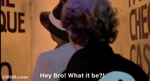 Man In Hat Talking To Man At Sign Hey Bro What It Be GIF