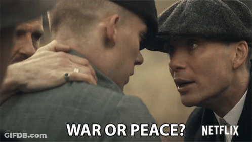Man In Hat Talks To Another Man Saying War Or Peace GIF