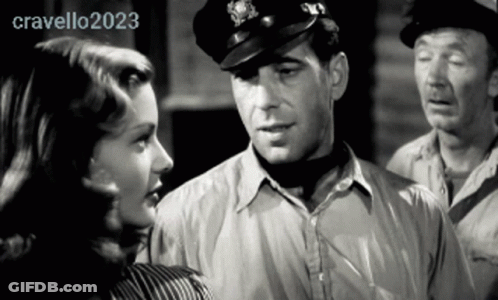 Man In Hat Talks To Woman In Black And White Photo GIF