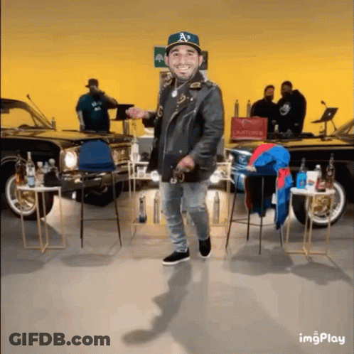 Man In Hat With Letter A Dancing In Front Of Cars GIF