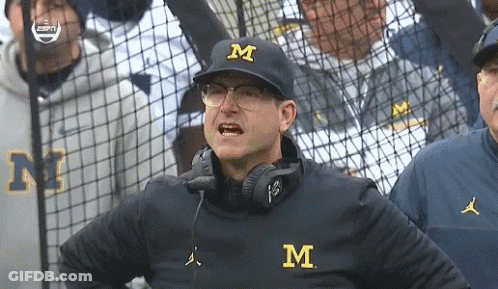 Man In Hat With Letter M In Front Of Fence GIF