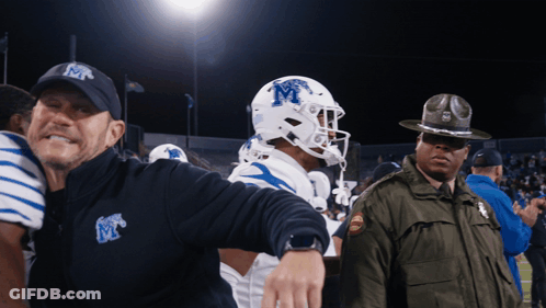 Man In Hat With Letter M Next To Football Player GIF
