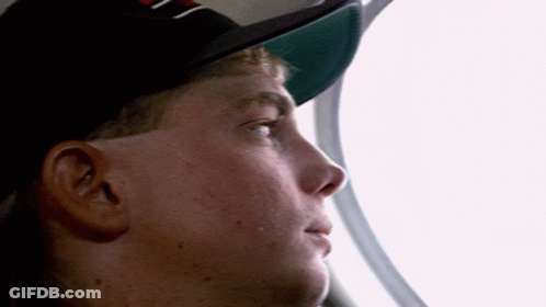 Man In Hat With Letter N Looking Out Window GIF