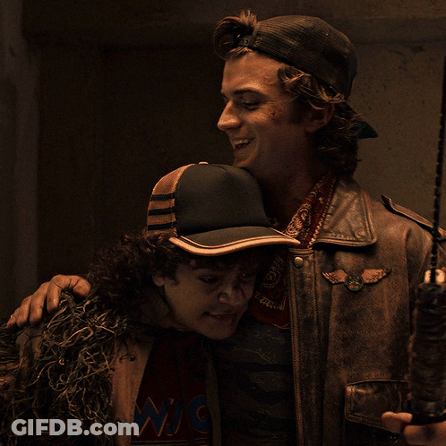 Man In Hat With W Hugging Jacketed Man GIF