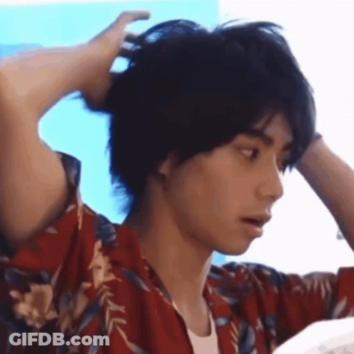Man In Hawaiian Shirt Holding Hair In Bun GIF