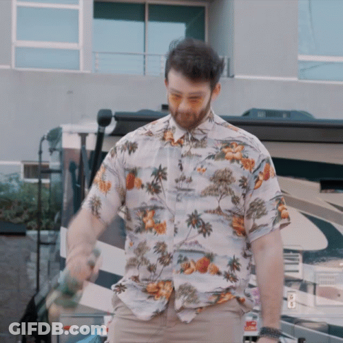 Man In Hawaiian Shirt Standing In Front Of Building GIF