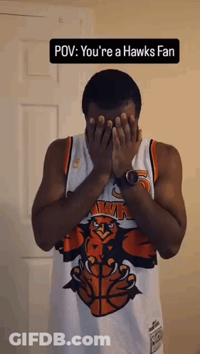 Man In Hawks Jersey Covering Face With Hands GIF
