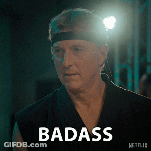 Man In Headband Standing In Front Of Badass Sign GIF