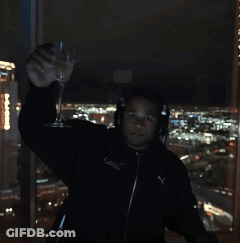 Man In Headphones And Black Puma Jacket Holding Wine Glass GIF